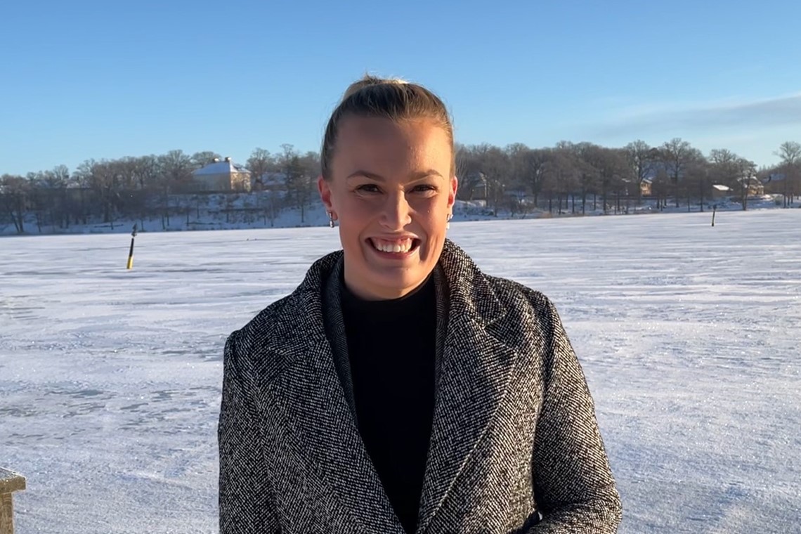 ESEM-medarbetaren Mathilde står vid en snötäckt sjö och ler.